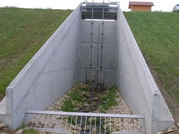 Durchlassbauwerk mit 5 m breiter Stauwand und Regulierschütze. Hergestellt aus 210 Tonnen Baustahl und 1600 m³ Beton.