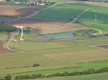 Blick vom Ipf auf Rückhaltebecken mit Erddamm und Ipfweiher